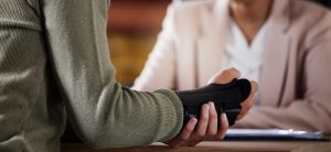 Injured employee holding a cast on their hand in a meeting with their employer